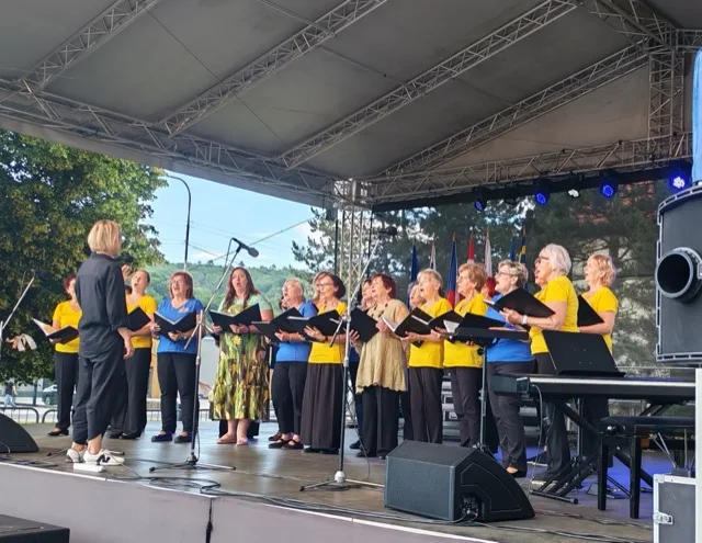 Choir performing on the stage in front of the House of Culture